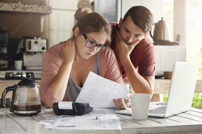 A man and woman trying to access their debt and liquidity ratios.